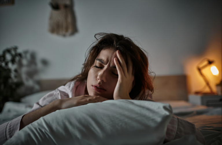Woman lying in bed exhausted after a full night of sleep